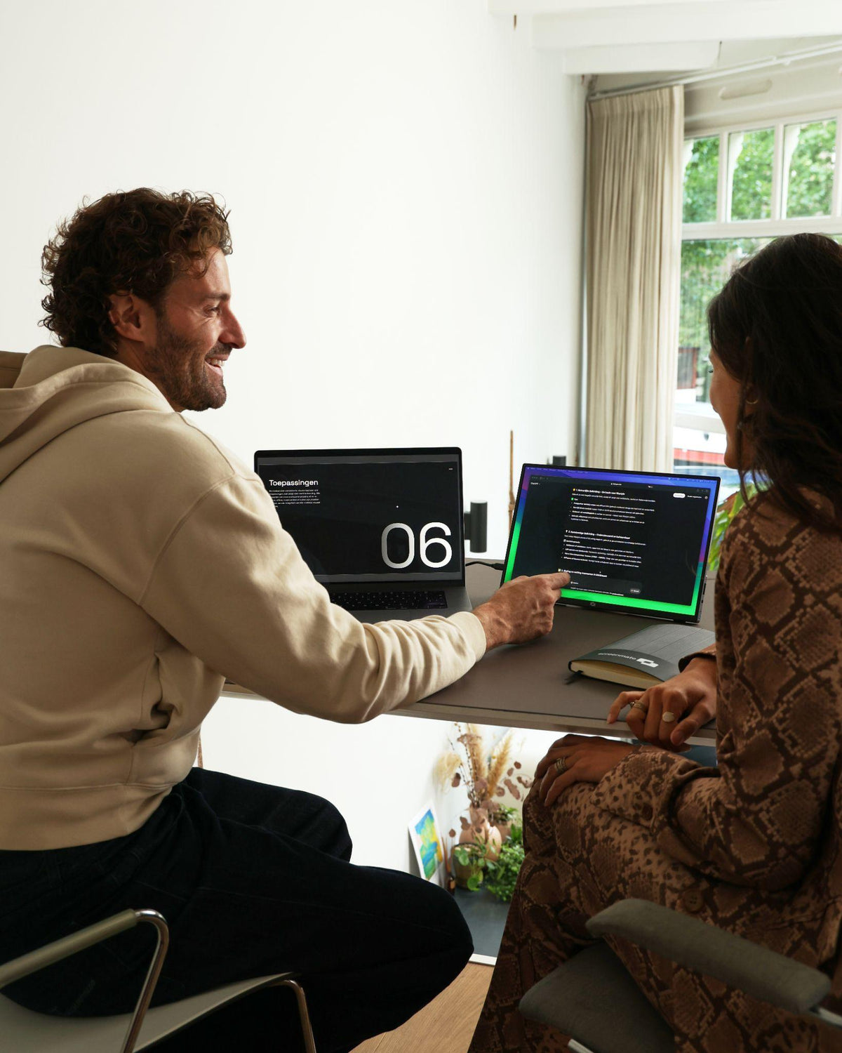 Twee professionals bekijken een presentatie op de Screenmate One 4K