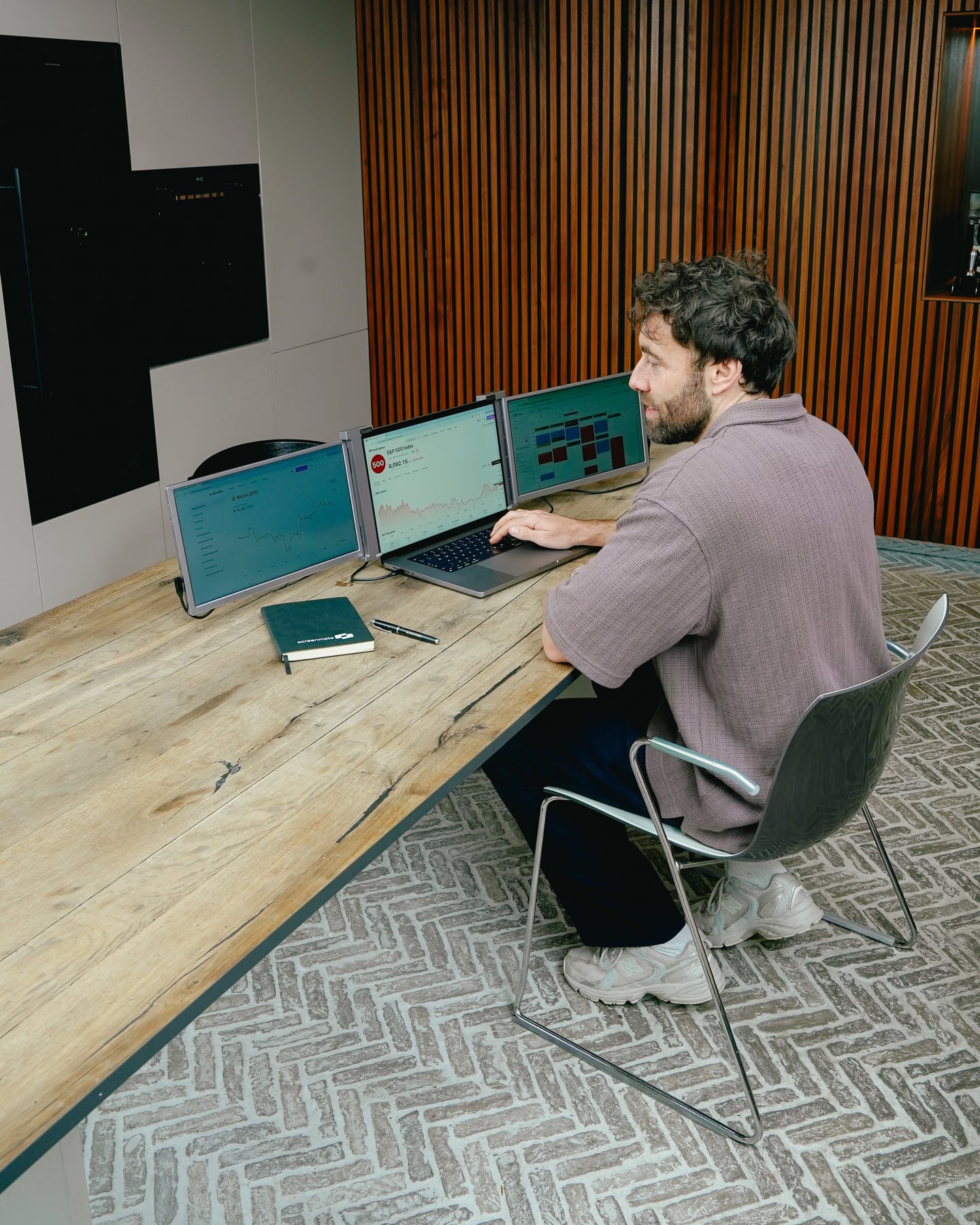 Man werkt op zijn laptop met twee extra grijze Expand-schermen