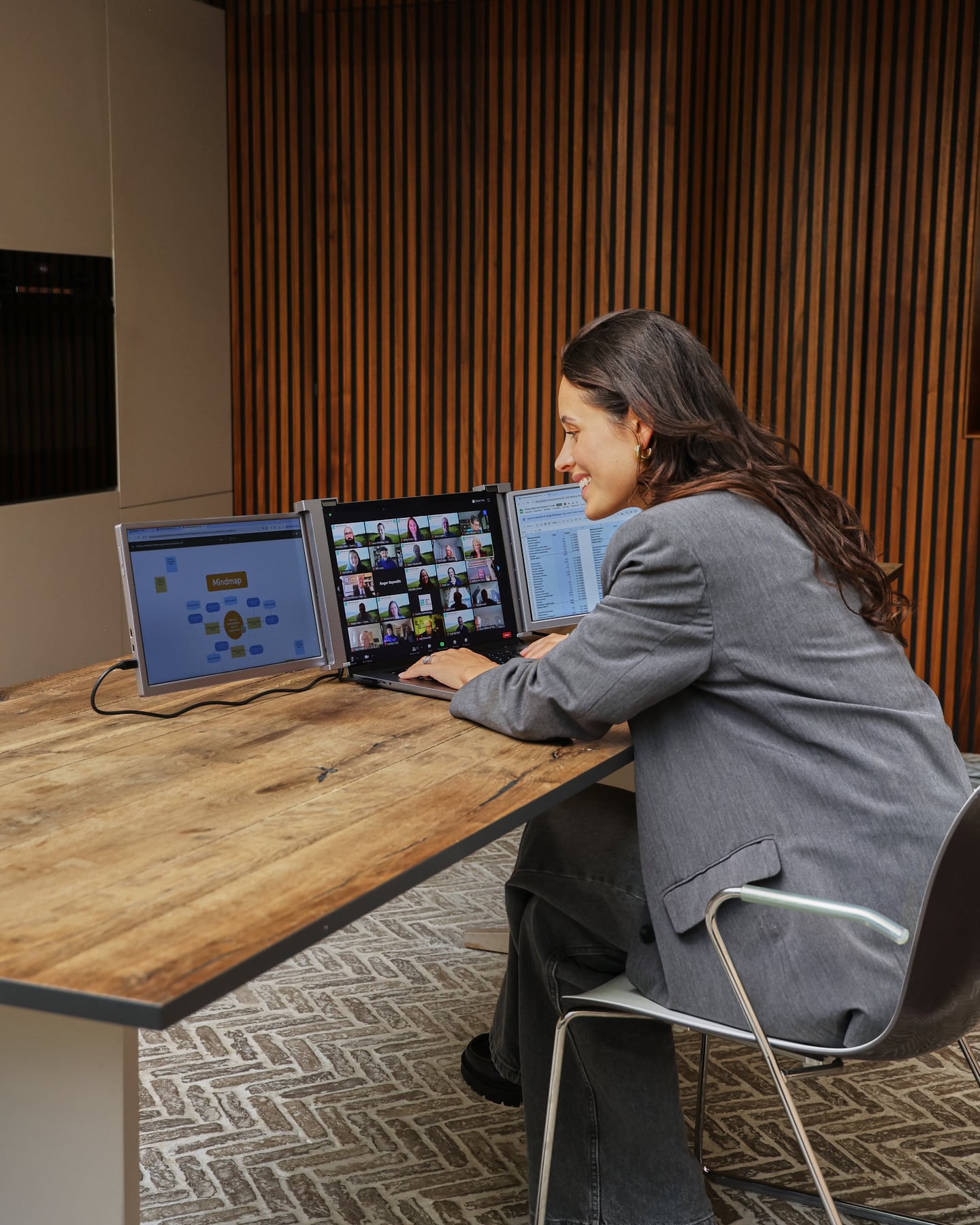 Vrouw werkt met de grijze Screenmate Expand tijdens een videogesprek