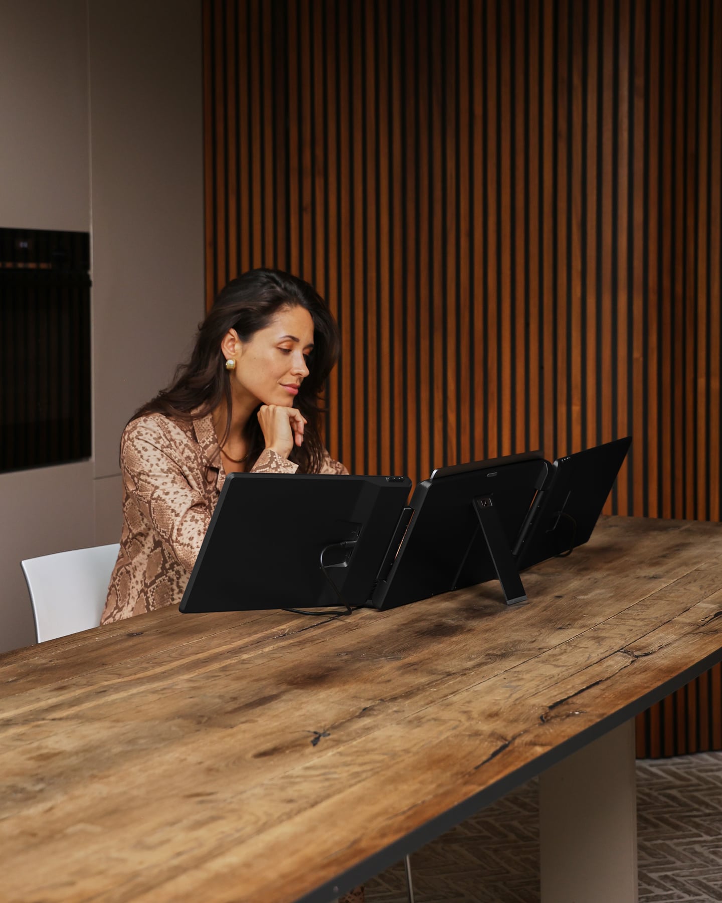 A woman is working at a table with the black Screenmate Flip