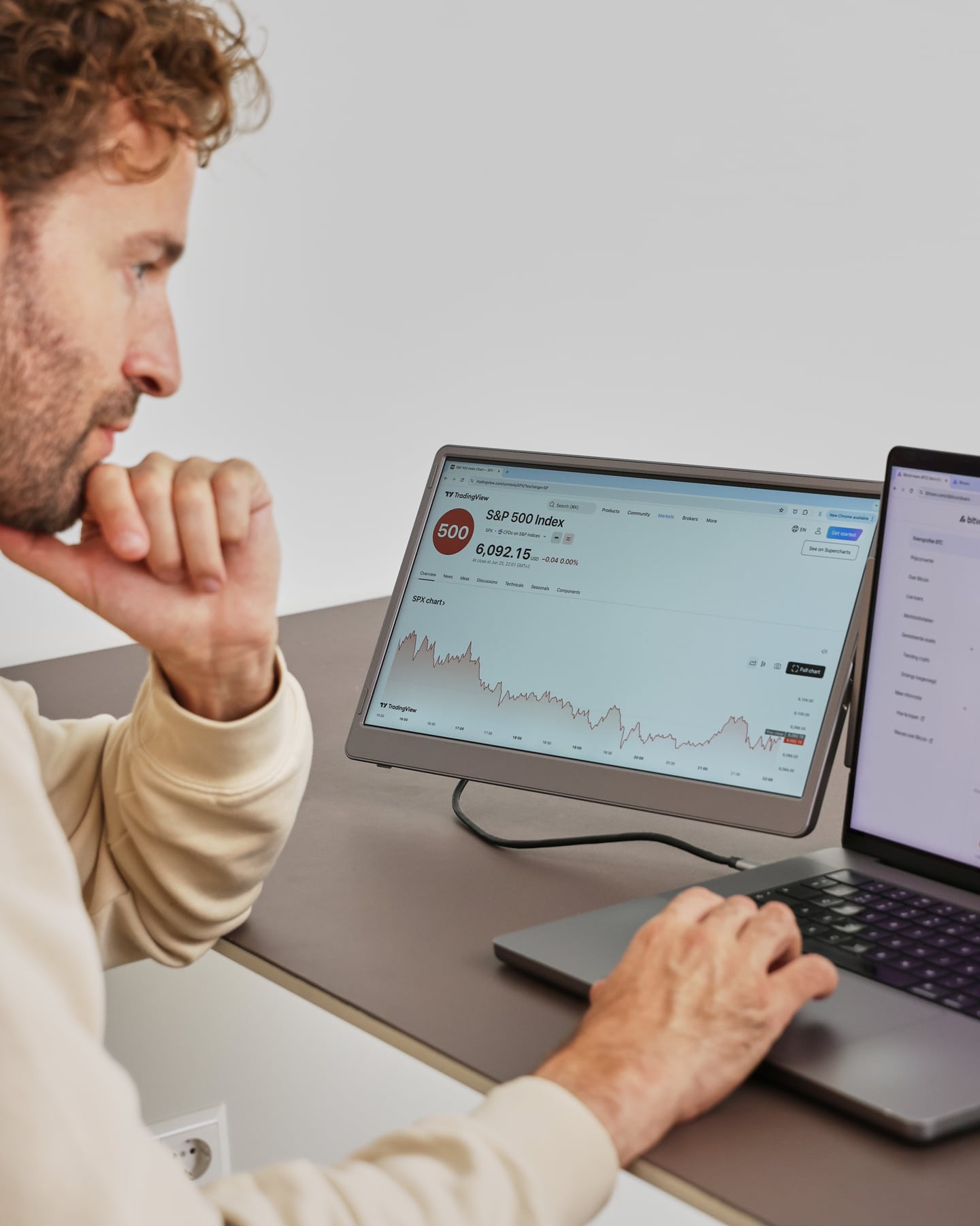 A man is working with the gray Screenmate Flip next to his laptop