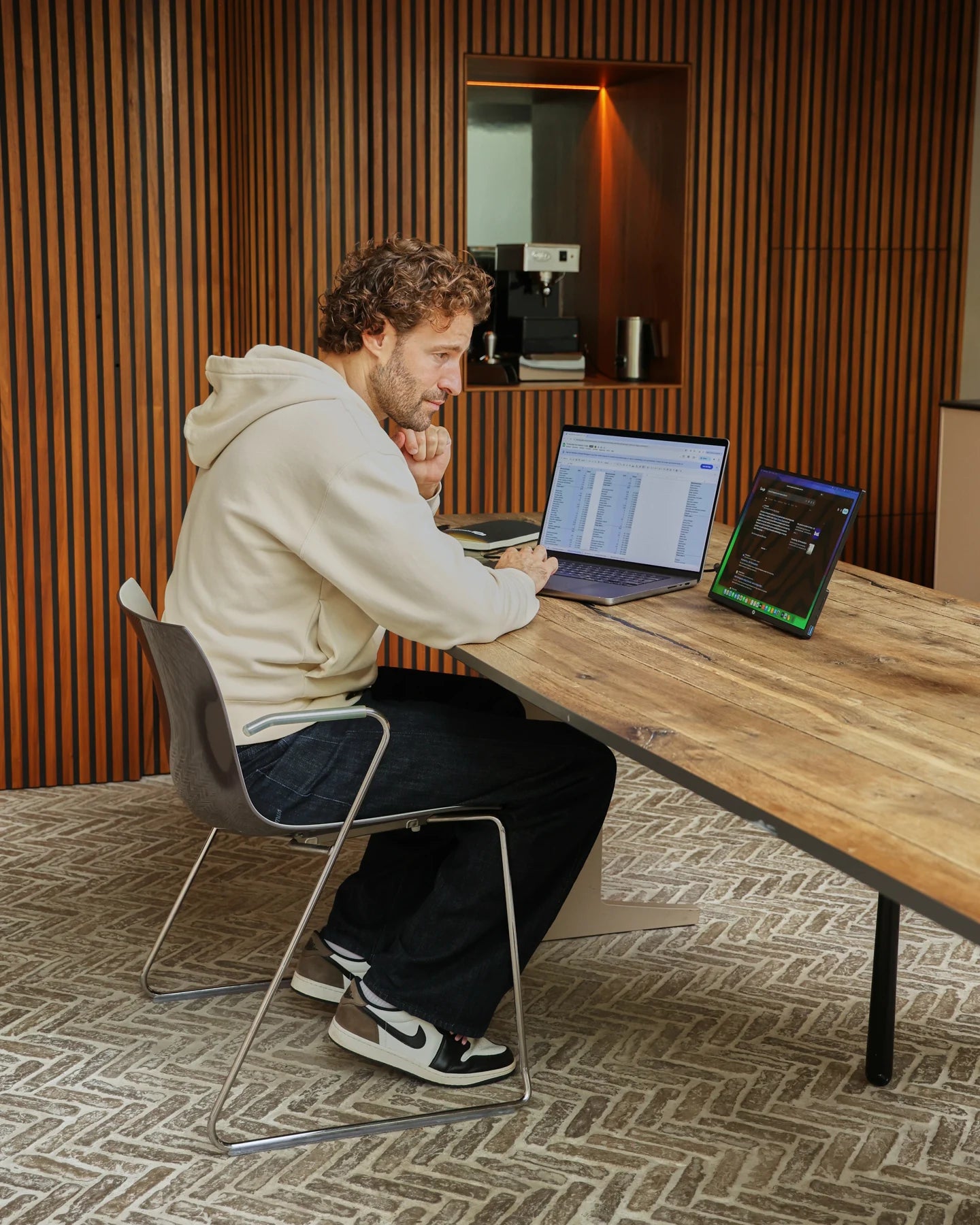 Geconcentreerd werken aan een houten tafel met de Screenmate One naast een laptop