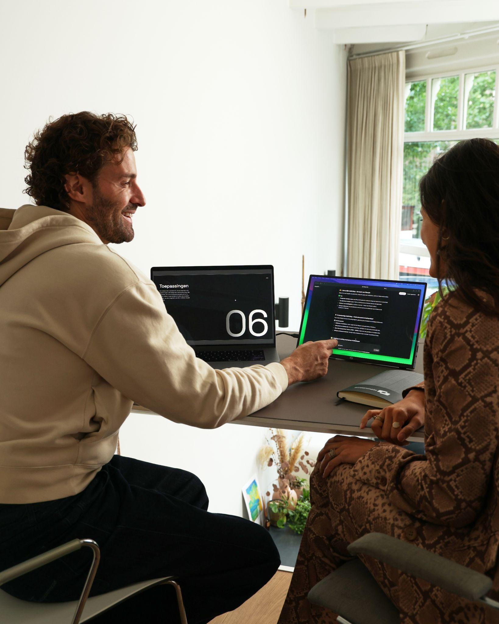 Twee collega’s werken samen met een Screenmate in een lichte werkruimte