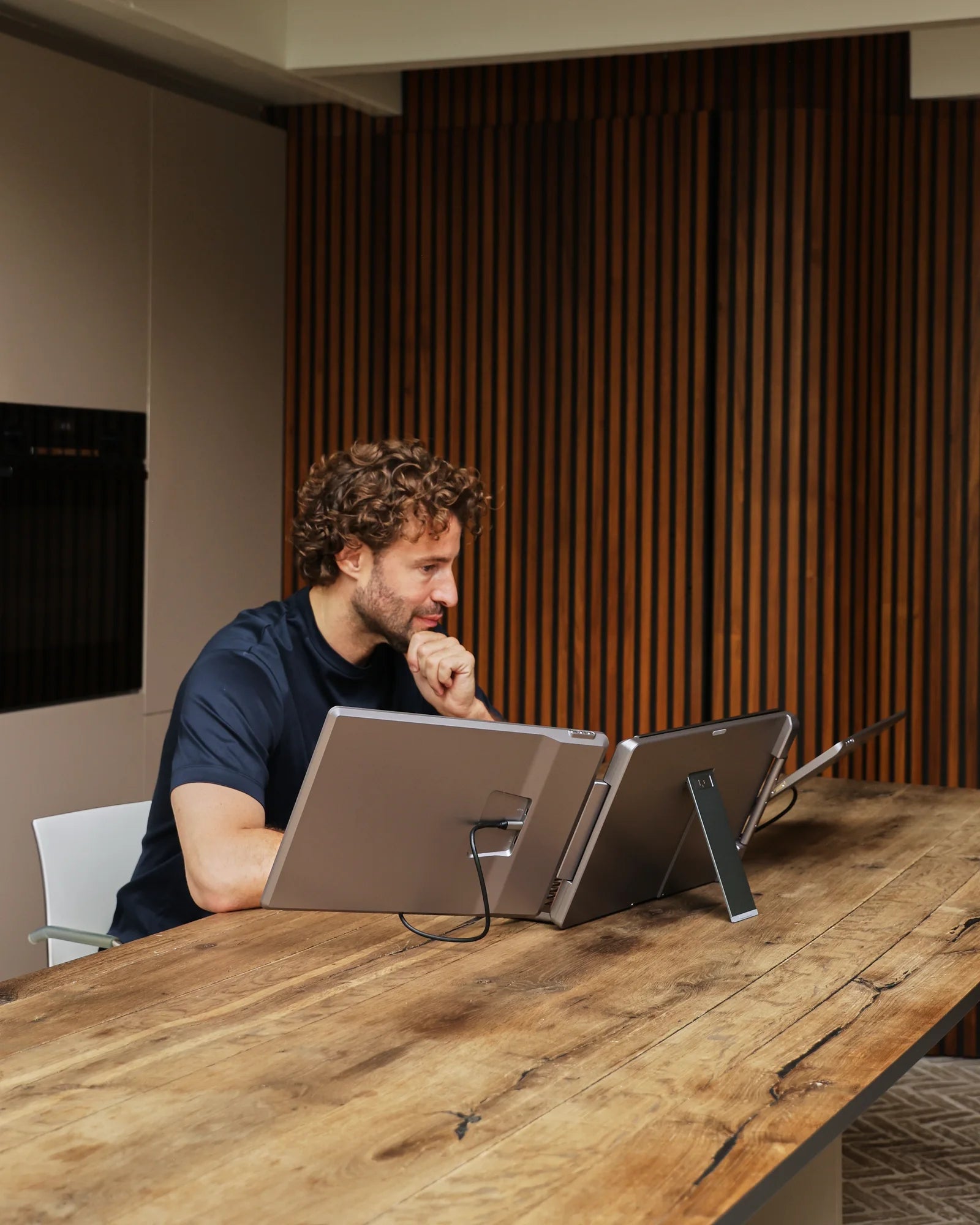 Professional werkt met de Screenmate Dual Flip aan een houten tafel