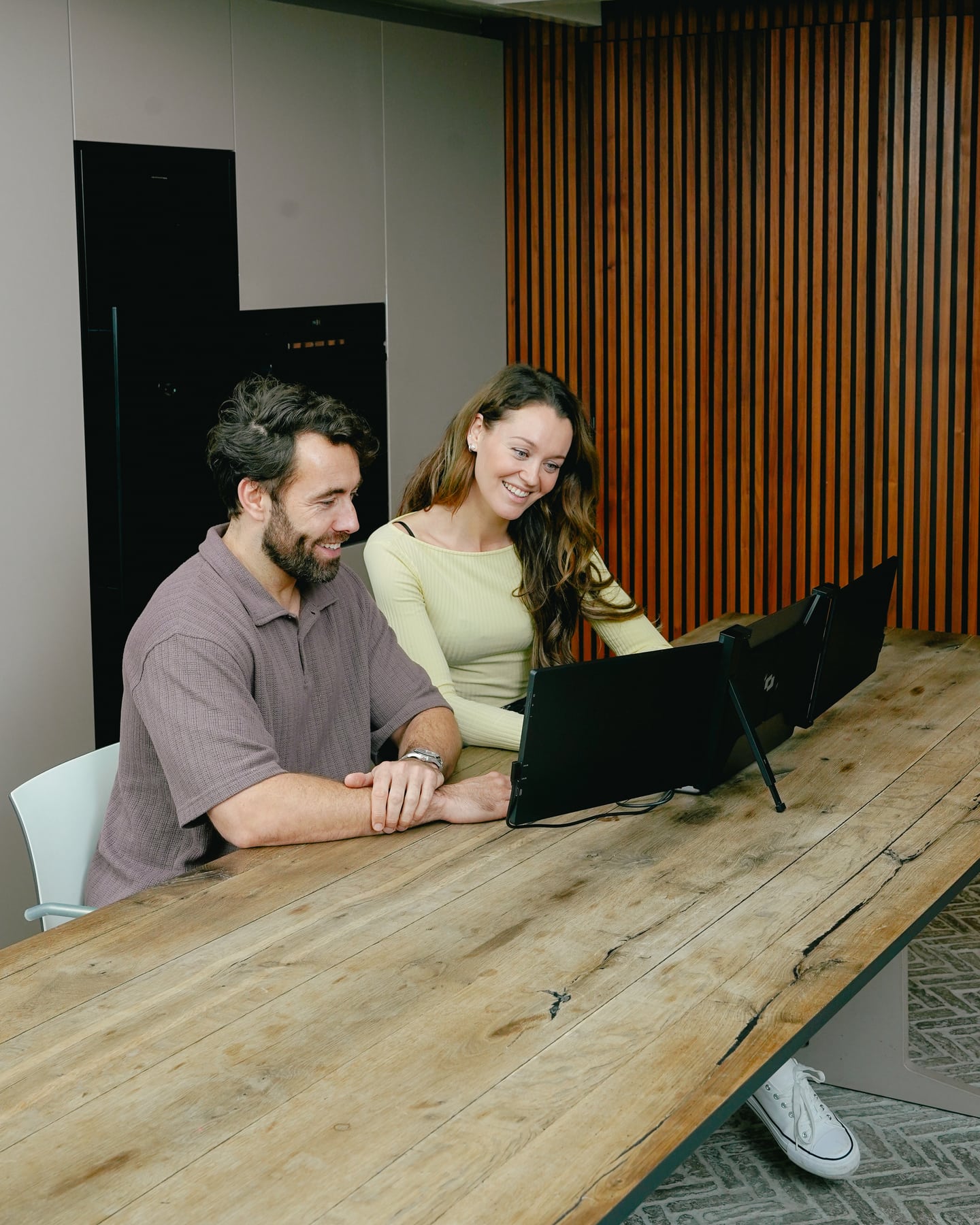 Twee mensen bekijken de achterzijde van de zwarte Screenmate Expand