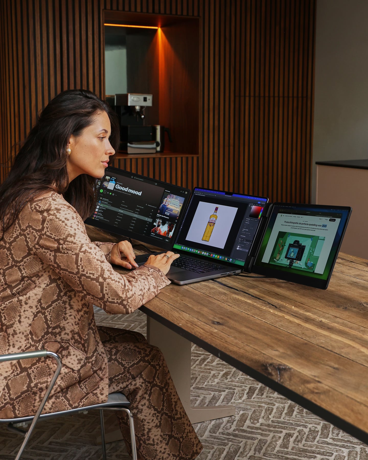 A woman is working on three screens using the black Screenmate Flip
