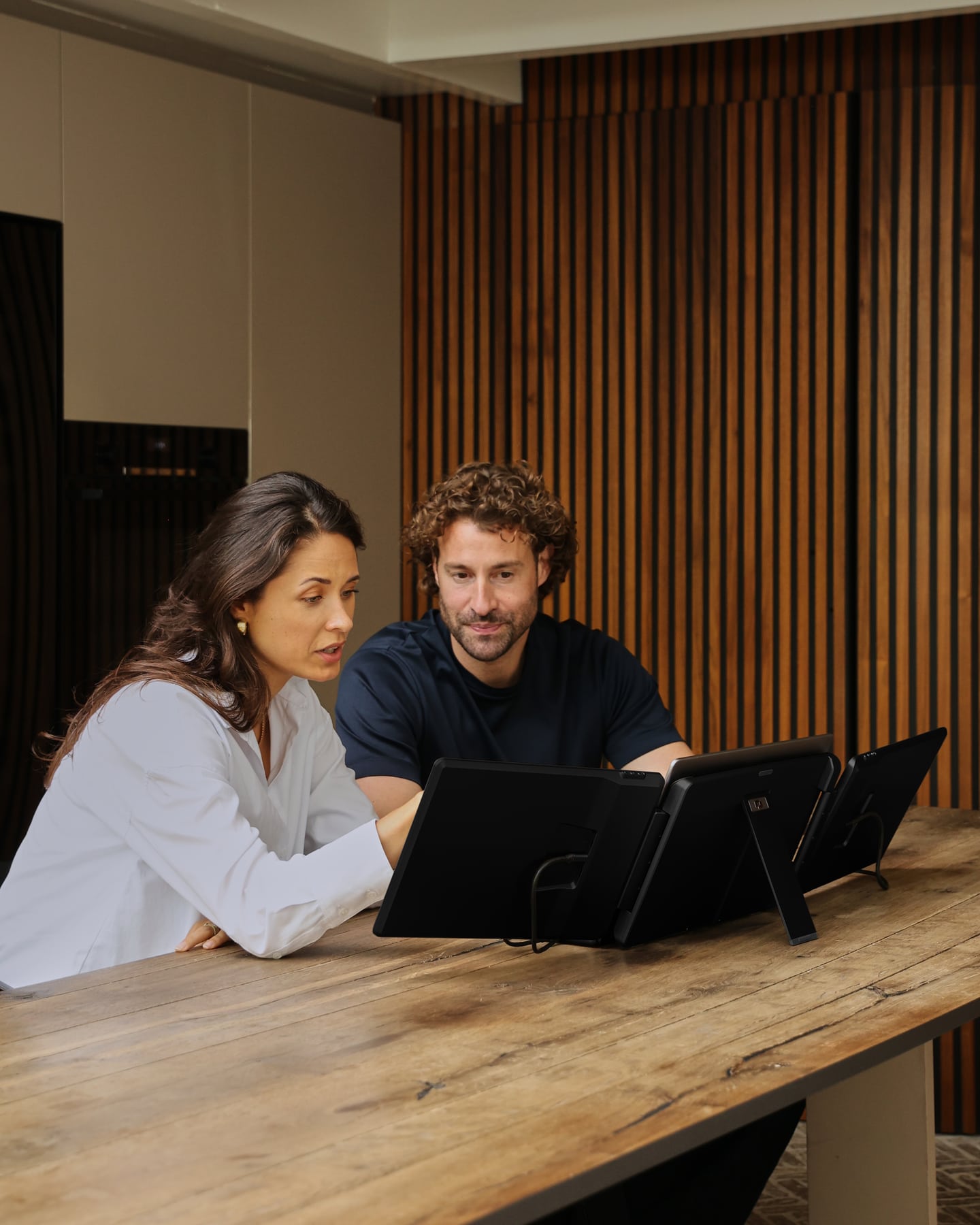 Two people are looking at the back of the black Screenmate Flip