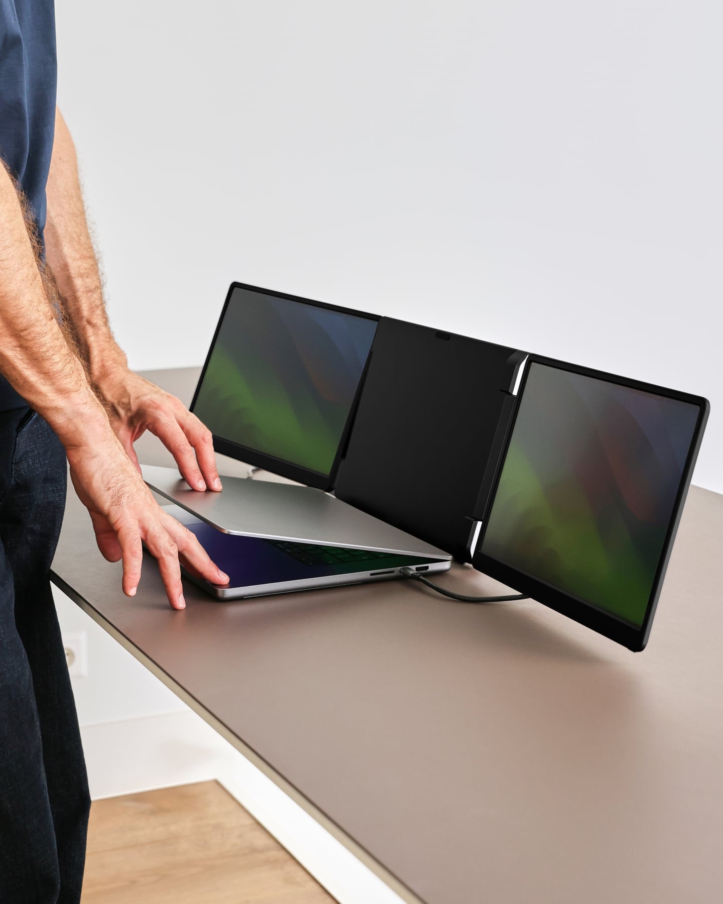 A man places the black Screenmate Flip next to his laptop