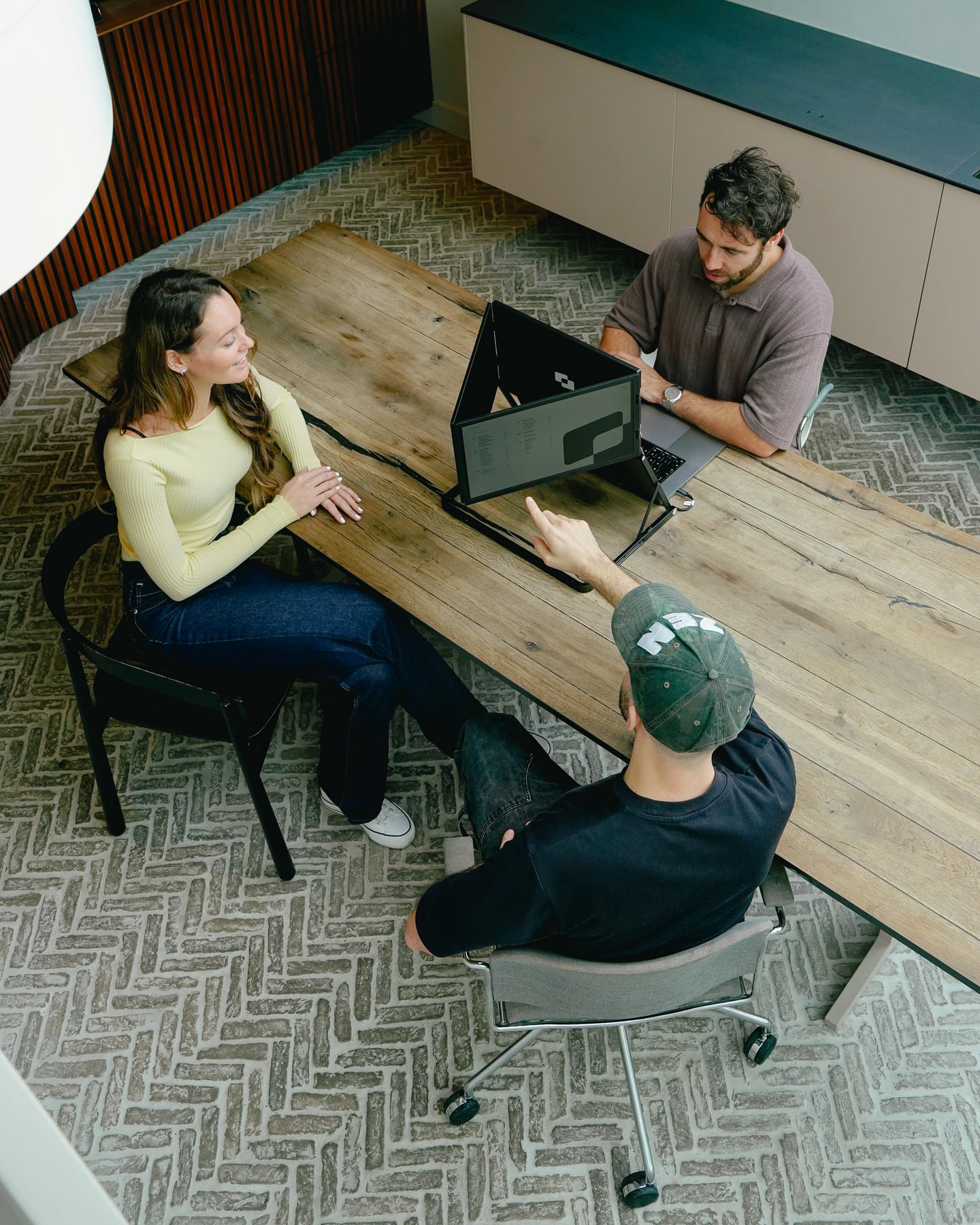 Drei Personen betrachten den Screenmate Panorama während einer Besprechung